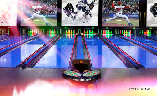 Blacklight Bowling lanes with sports on the screen