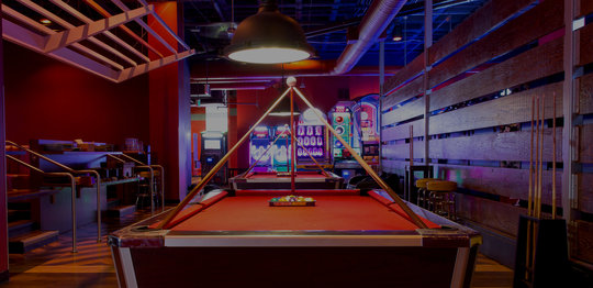 Pool table with arcade area in background
