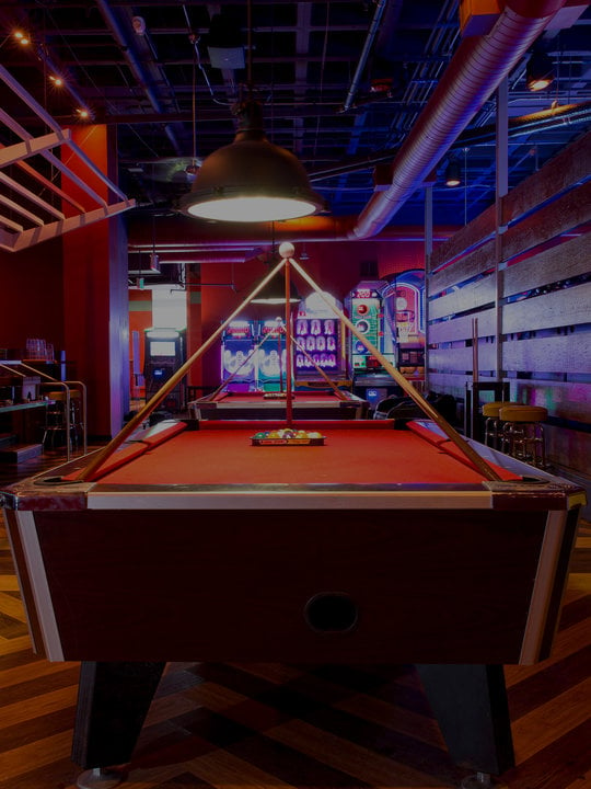 pool table with arcade area in background