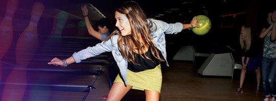 Action shot of young woman bowling