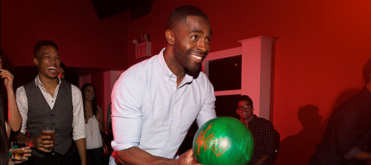 Man holding a green bowling ball